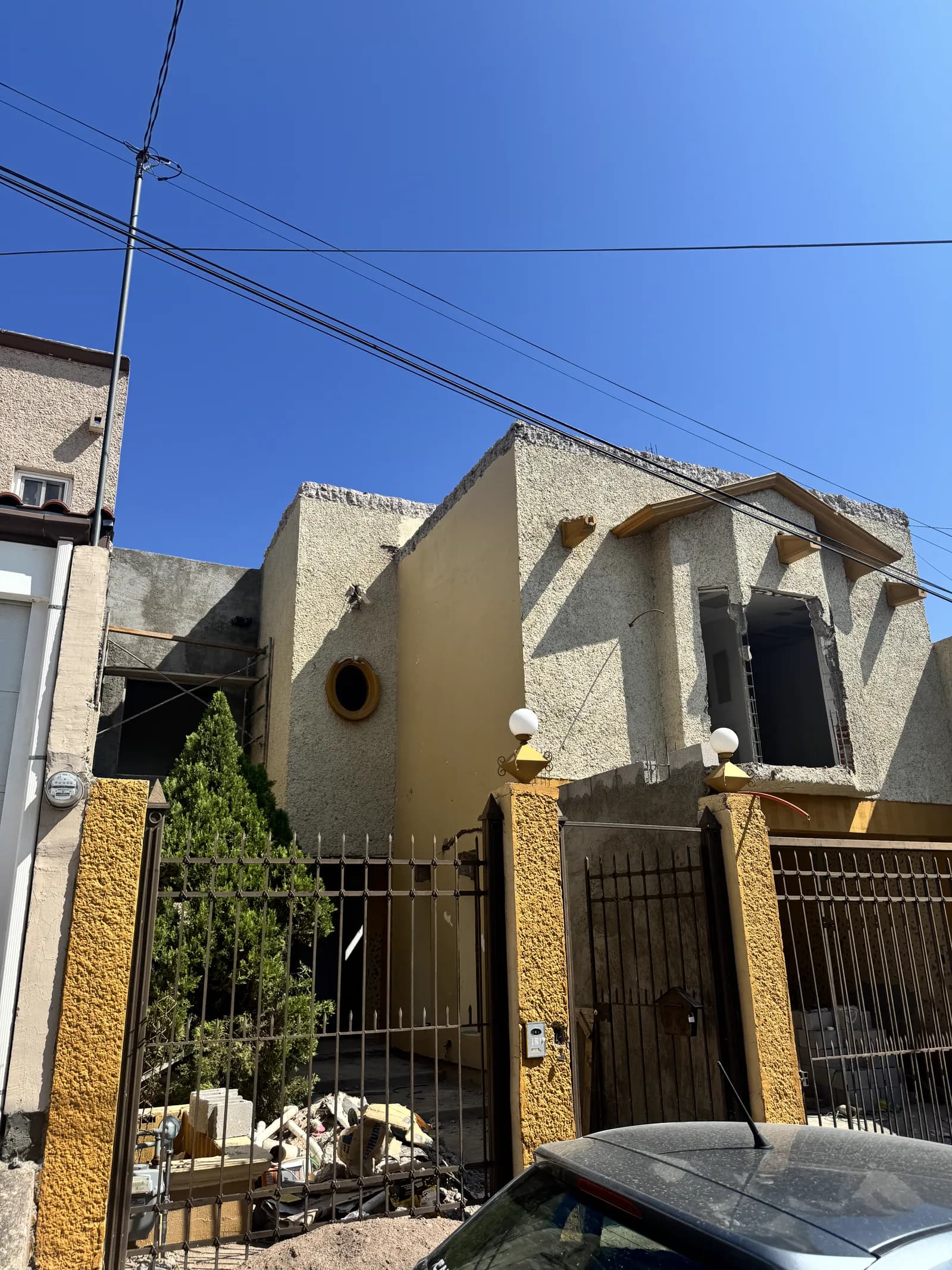 Fachada original antes de la remodelación, con aplanado amarillo y herrería.