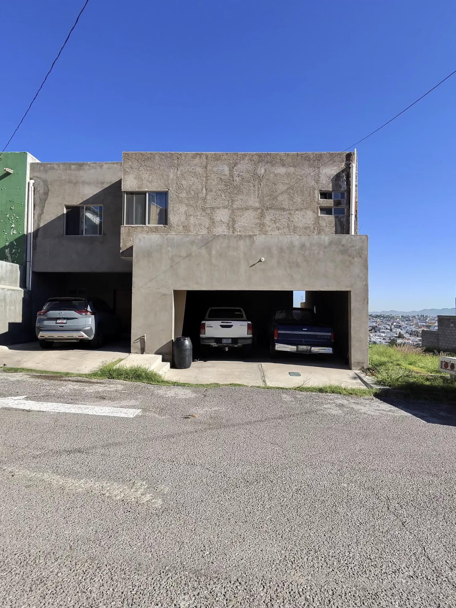 La casa antes de la obra, con la fachada en obra gris.