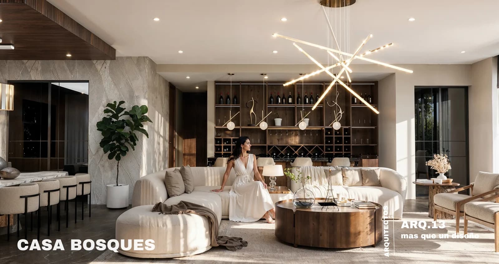 Render de la sala con sillones curvos claros, mesa de centro de madera y la cava al fondo.