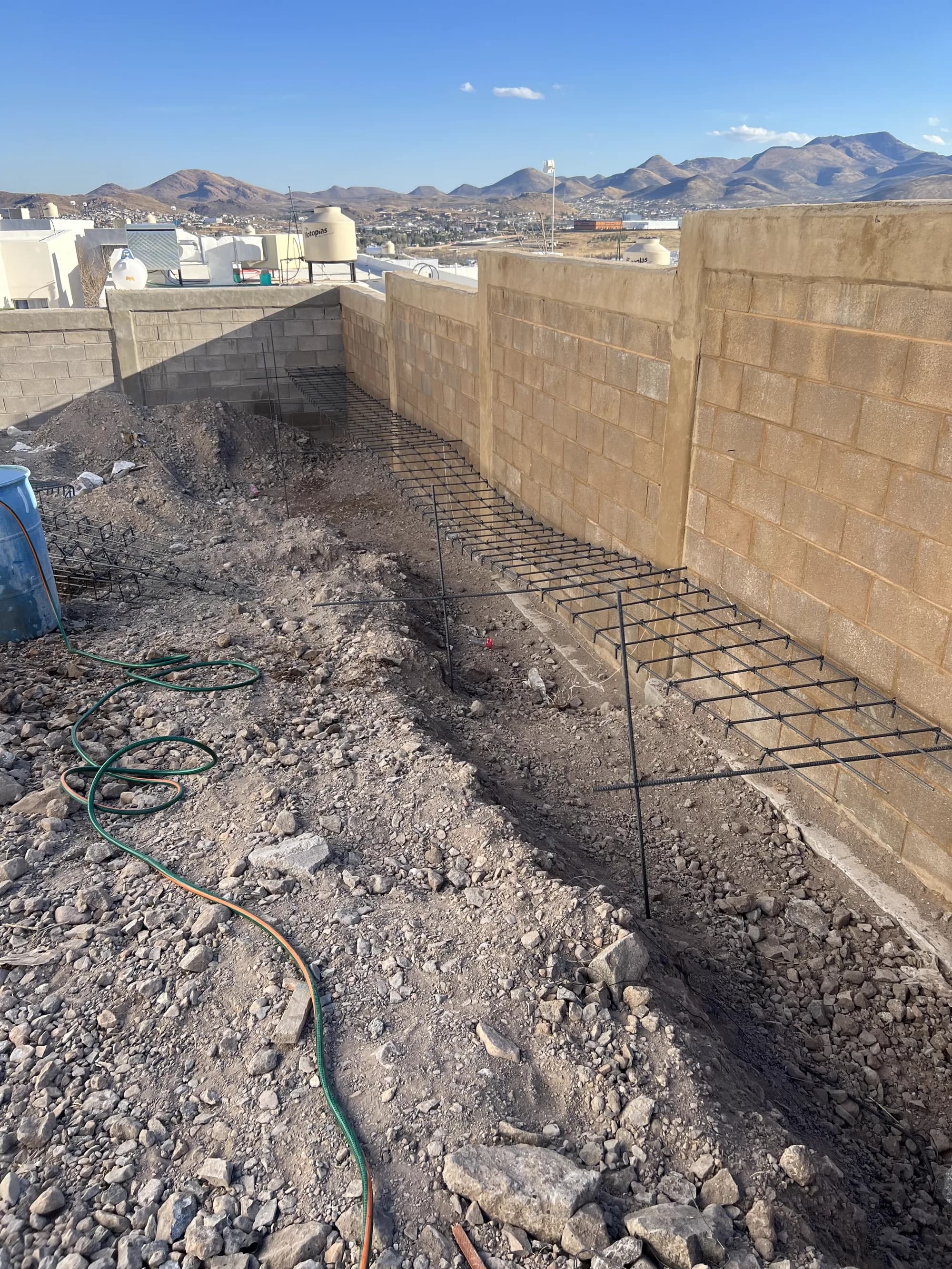 Excavación al pie del muro de contención, con el armado de acero de la cimentación.