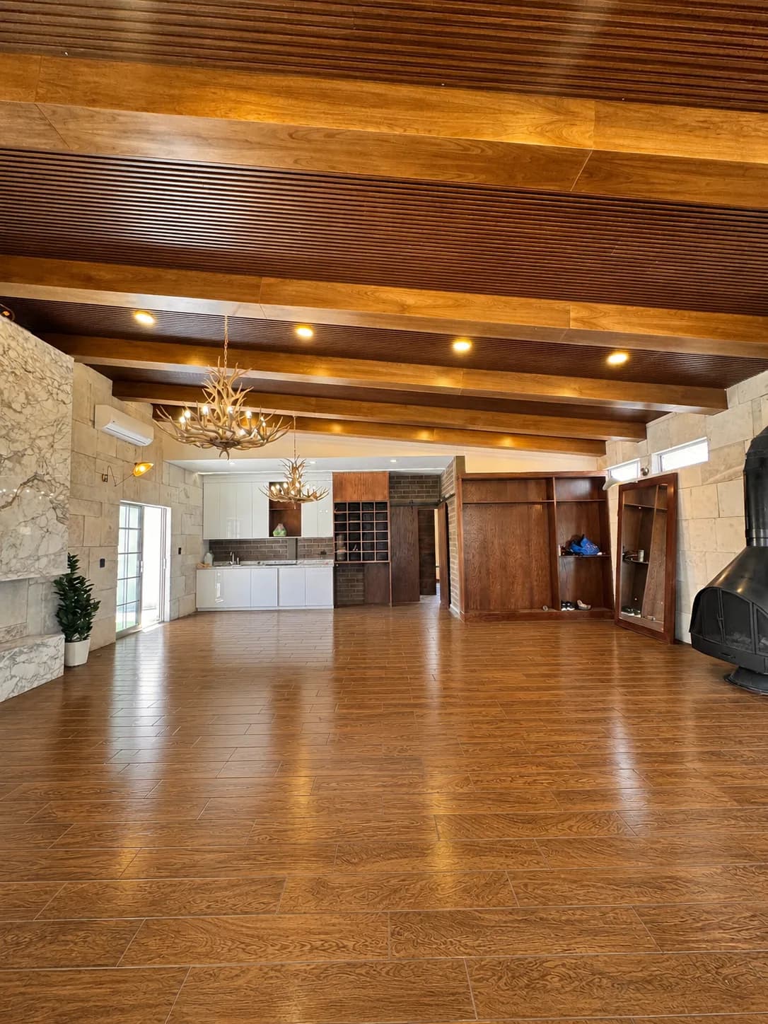 Vista a lo largo del salón hacia la cocina integrada, bajo las vigas de madera.