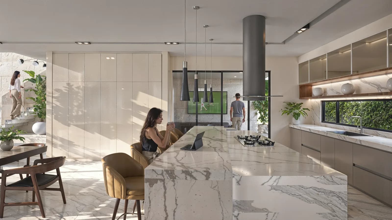 Render de la isla de mármol veteado con la cocina y la escalera al fondo.
