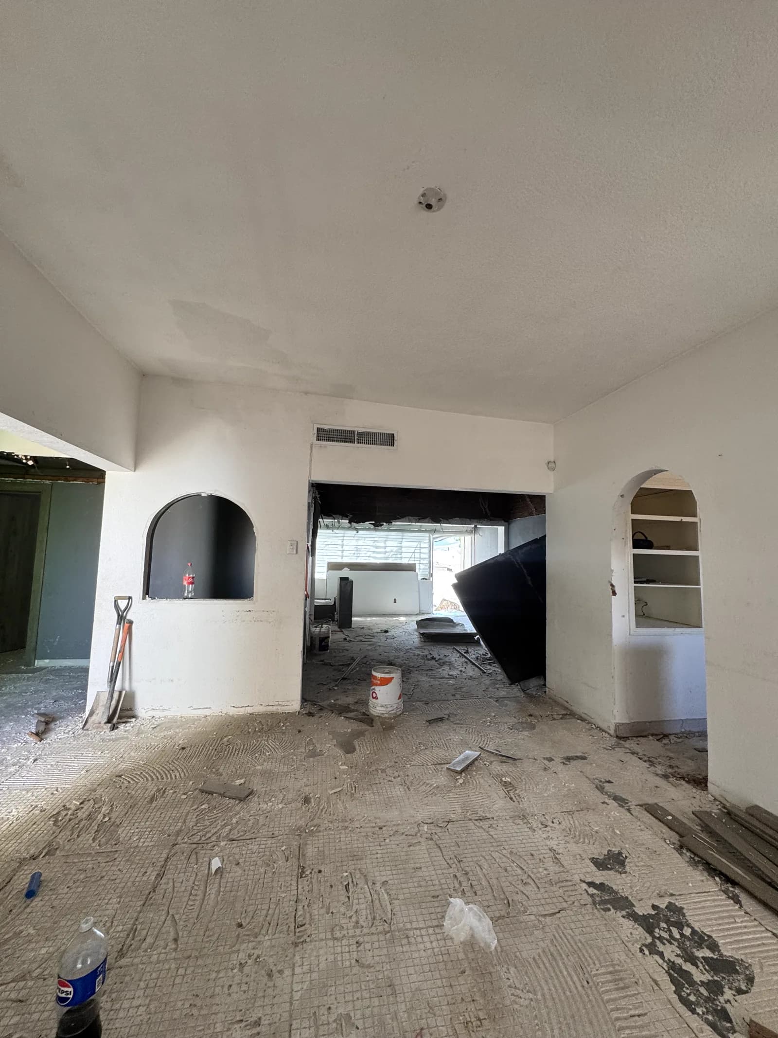 Estancia en obra, con el piso levantado y los nichos en arco originales.