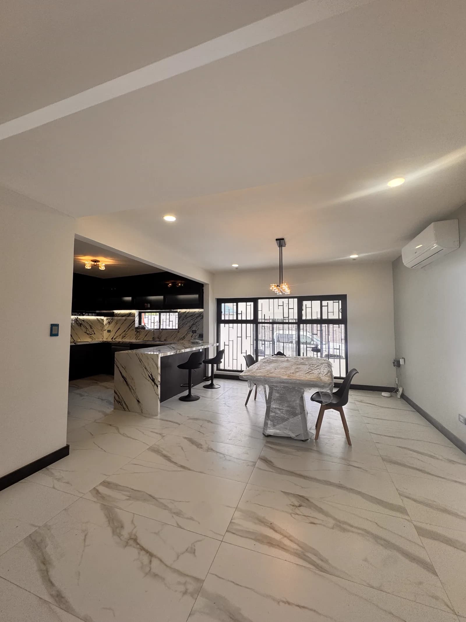 Comedor y cocina terminados, con la isla de mármol veteado.