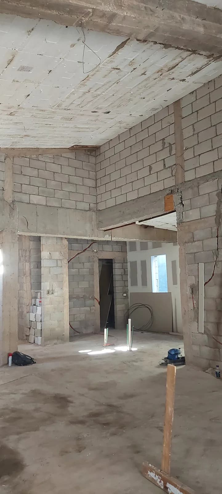 Interior en obra gris a doble altura, con la losa cimbrada a la vista y los muros de block sin recubrir.