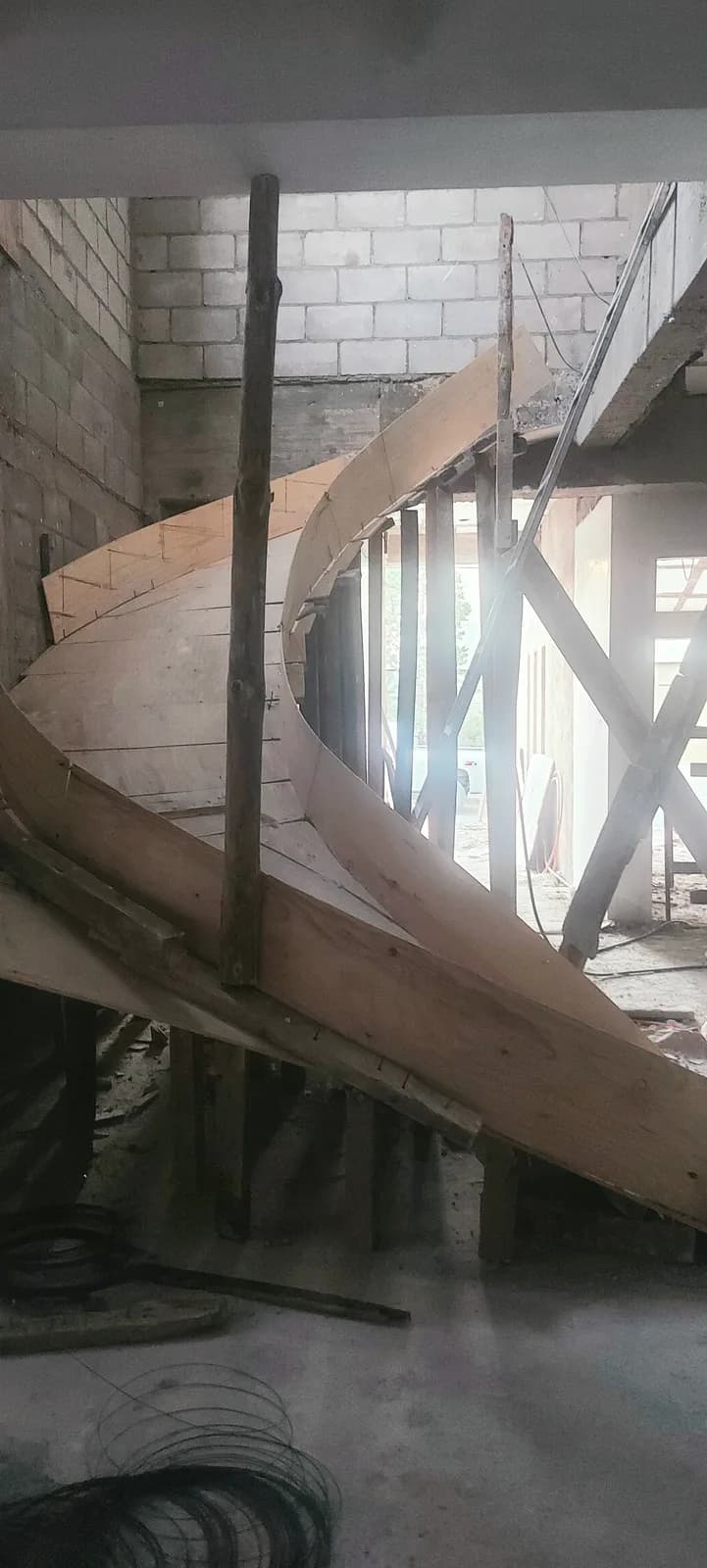 Cimbra curva de madera de la escalera helicoidal, apuntalada antes del colado.