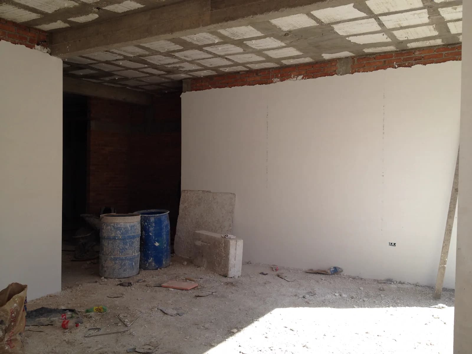 Cuarto con muros blancos y material de obra.