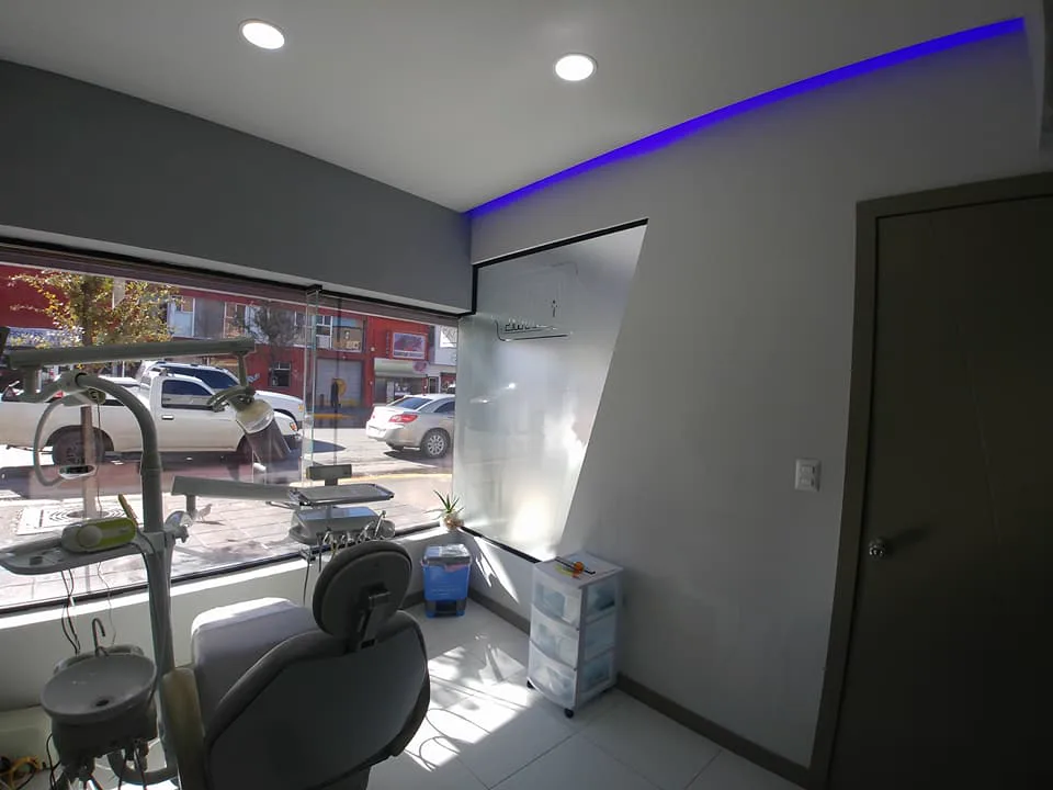 Consultorio con sillón dental junto al ventanal hacia la calle.