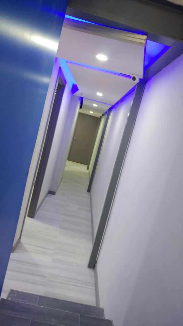 Pasillo del entrepiso con el muro azul y la luz indirecta.