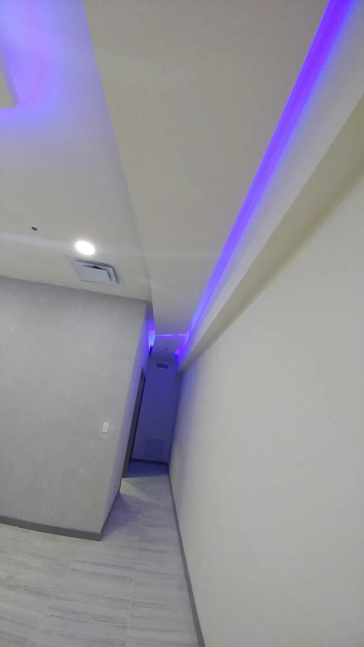 Pasillo blanco con la línea de luz azul.