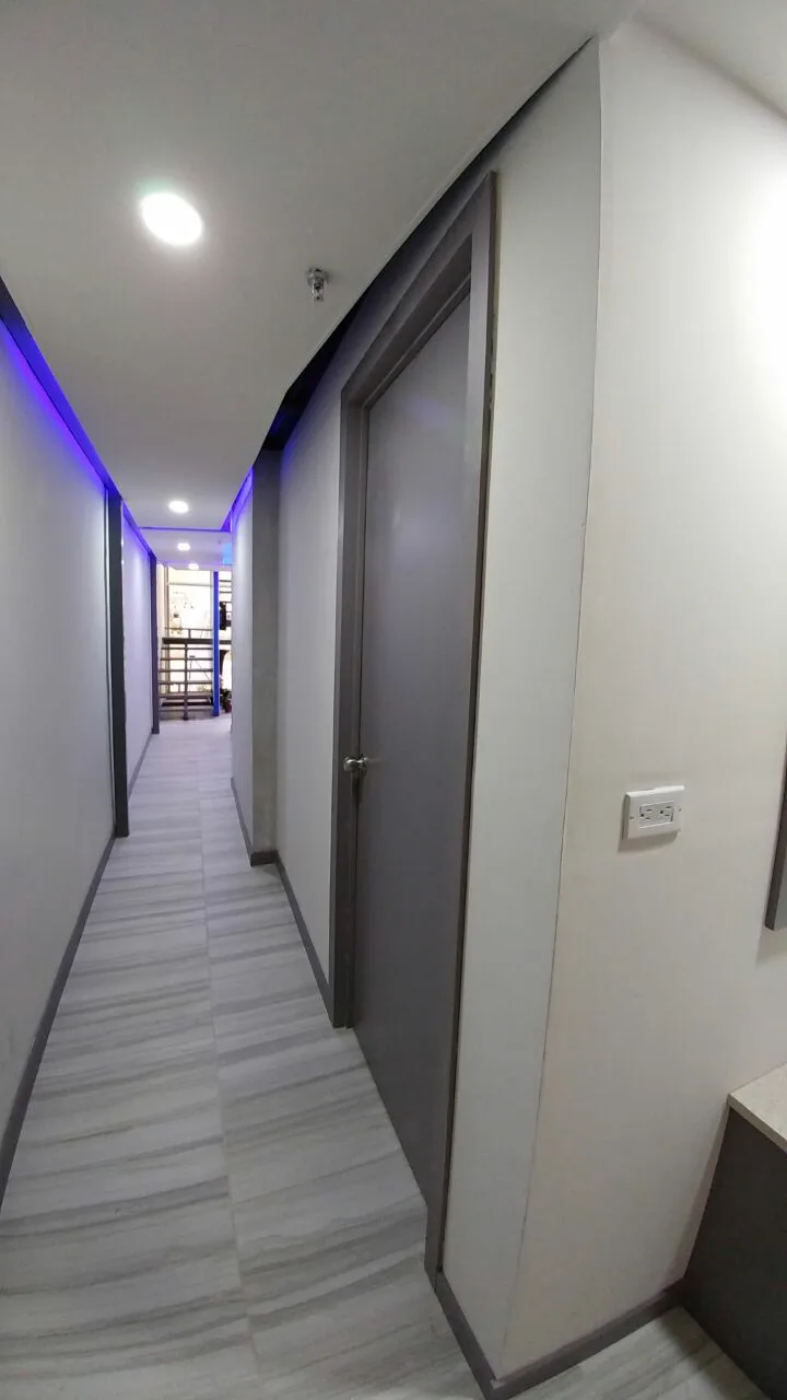 Pasillo de consultorios con puertas grises.