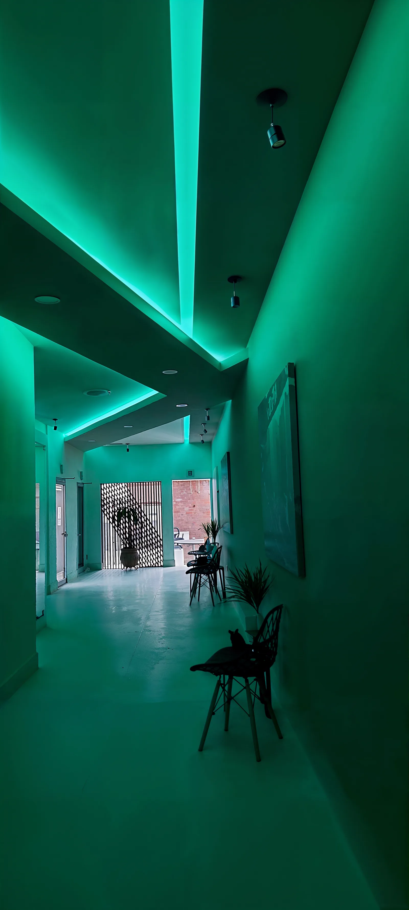 Pasillo iluminado en verde con una línea de luz en el plafón.