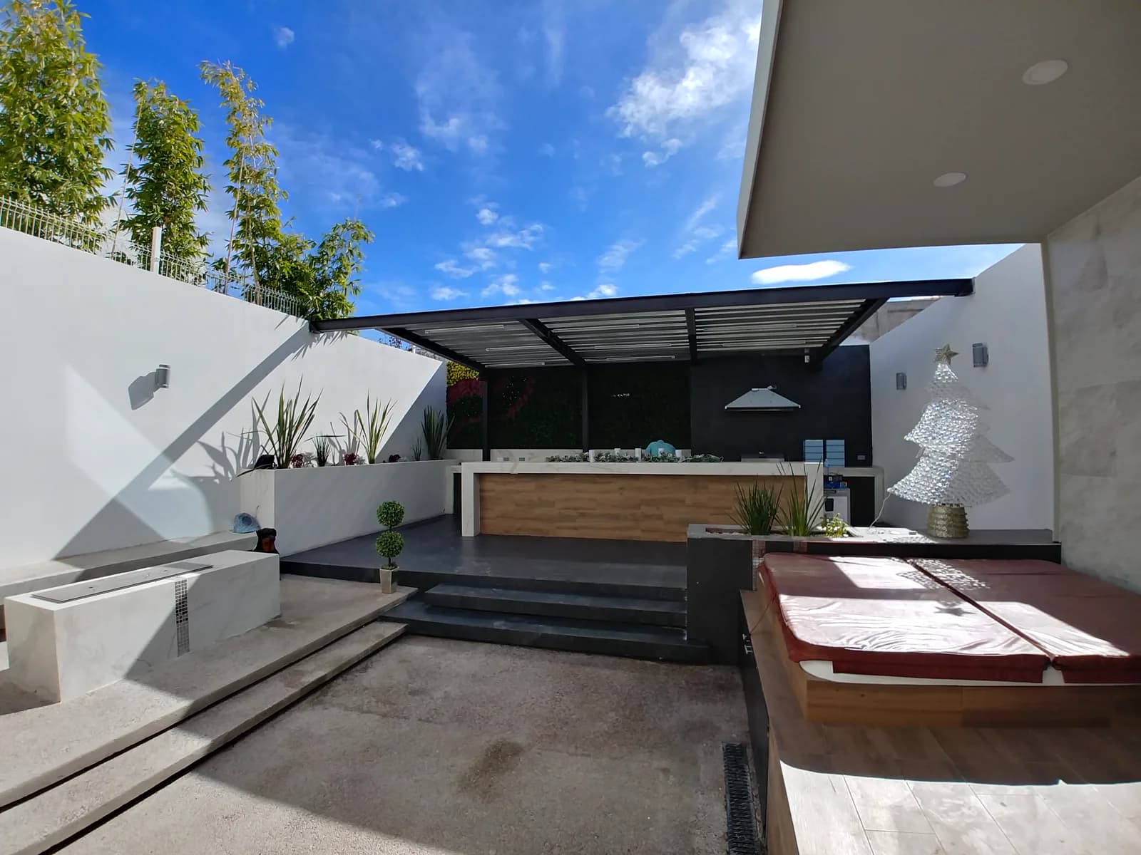 Otra vista del patio hacia la terraza, con la jardinera blanca en primer plano.