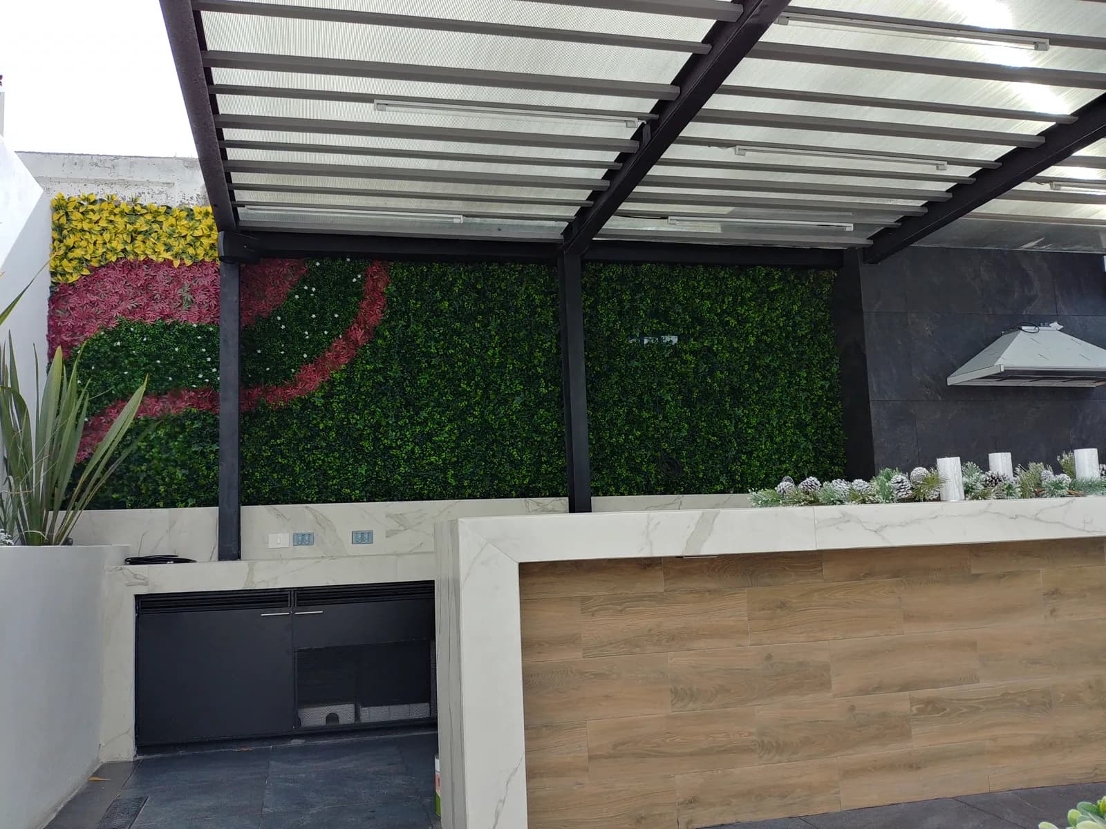 Muro verde con figuras de flores detrás de la barra y los gabinetes negros.