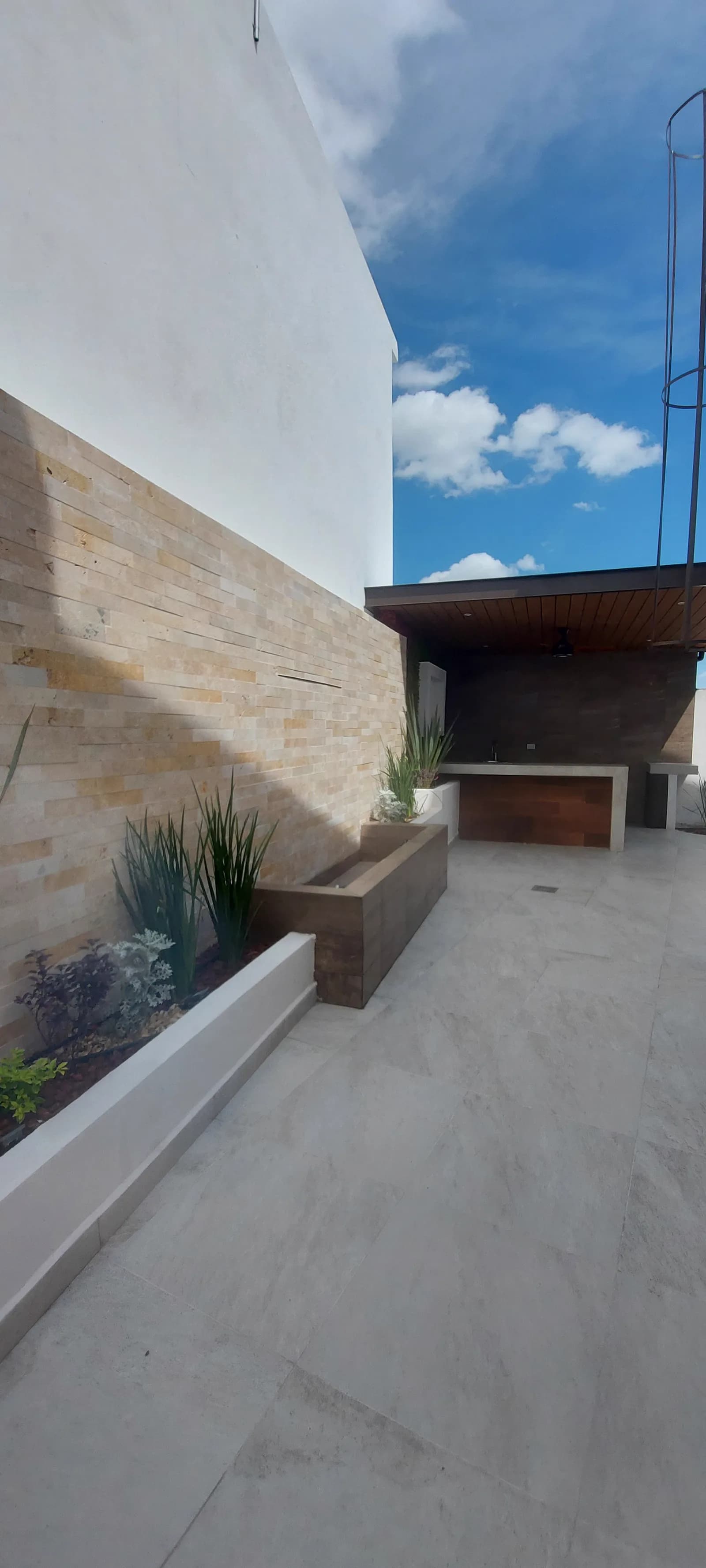 Pasillo del patio hacia la terraza techada, junto a la jardinera.