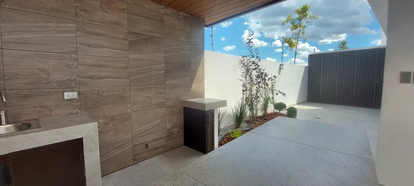 Barra junto al muro de porcelanato tipo madera, con el portón al fondo.