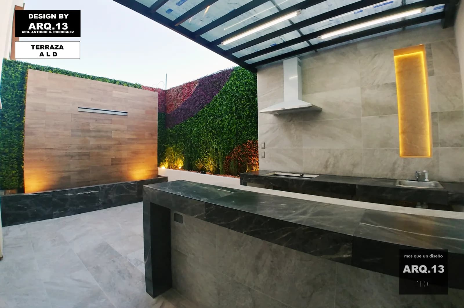 Barra de mármol oscuro y cocina bajo la techumbre, con el muro de madera iluminado.