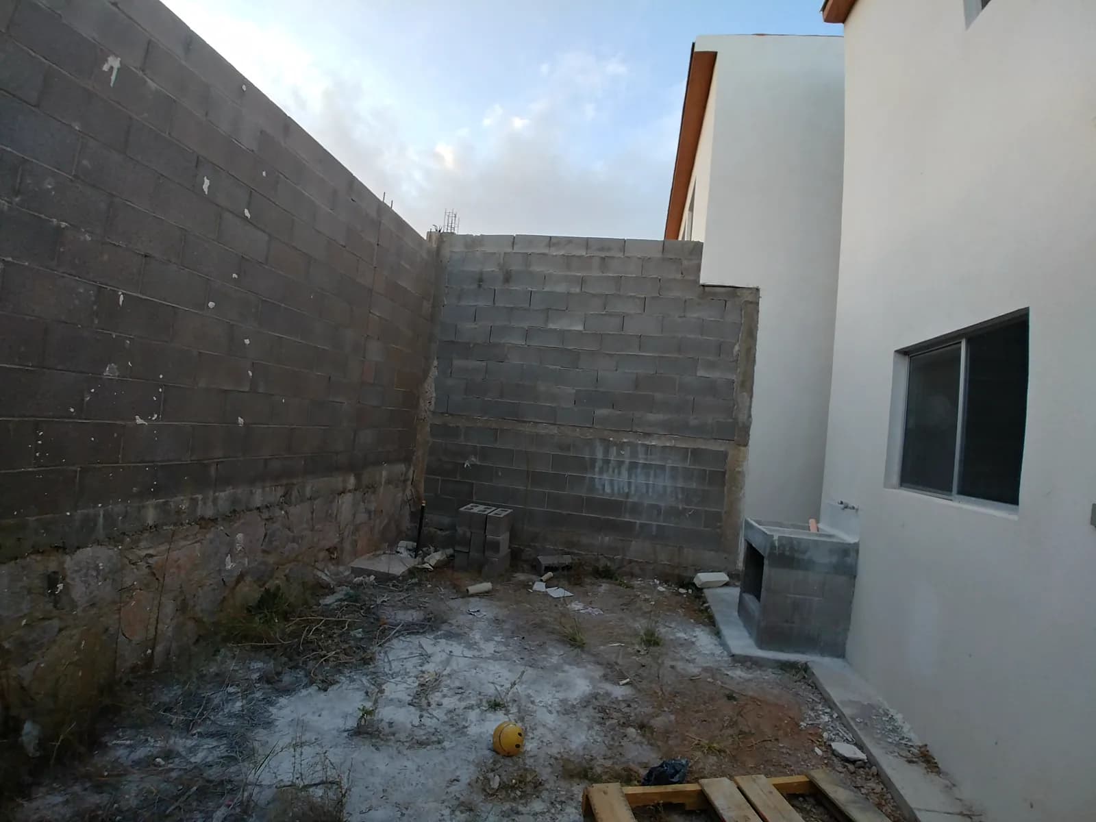 Otra vista del patio antes de la obra, con los muros de block sin acabado.