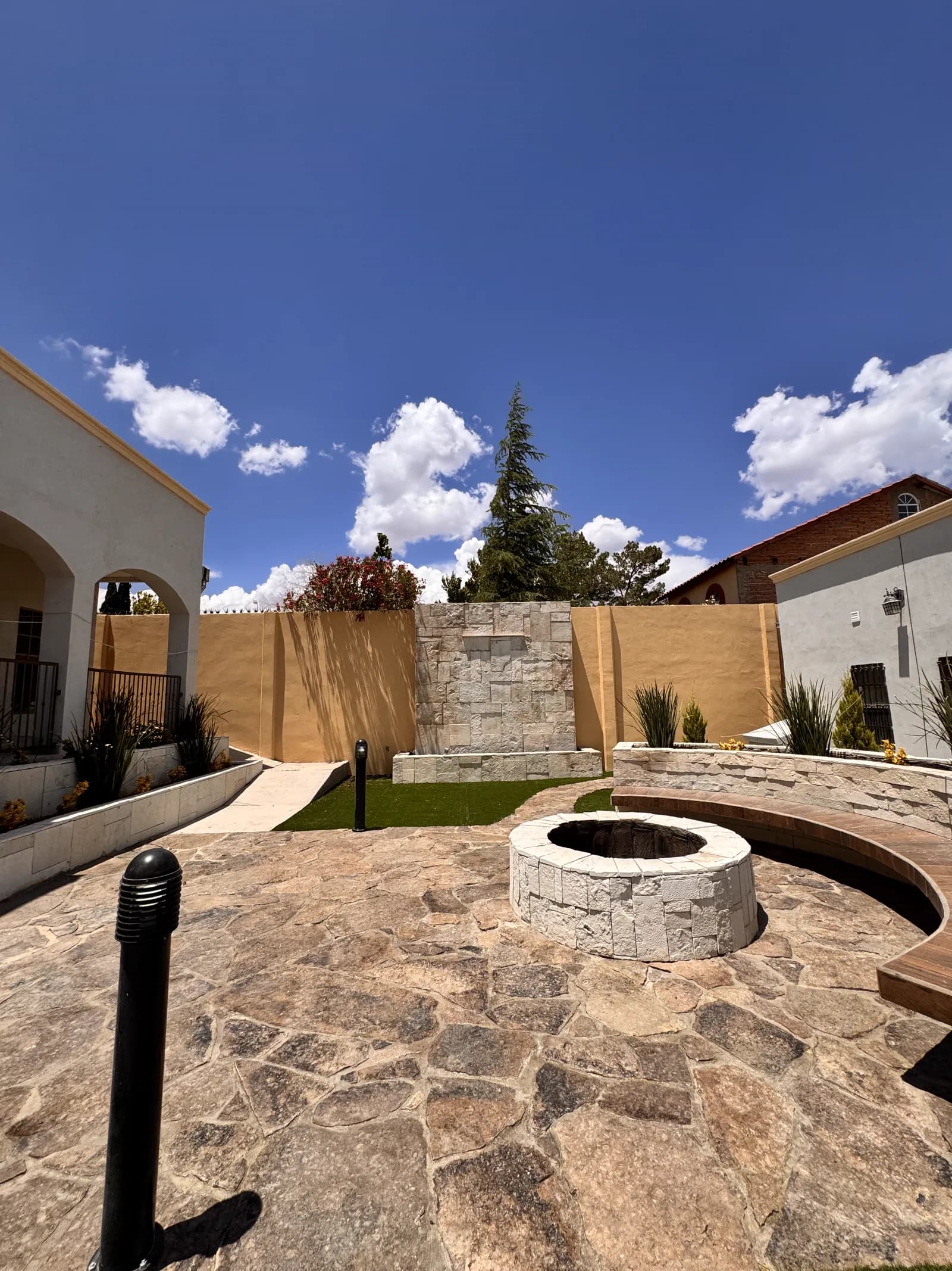 Patio de Terraza Casas Grandes, con piso de laja de piedra, fogón circular y banca curva.