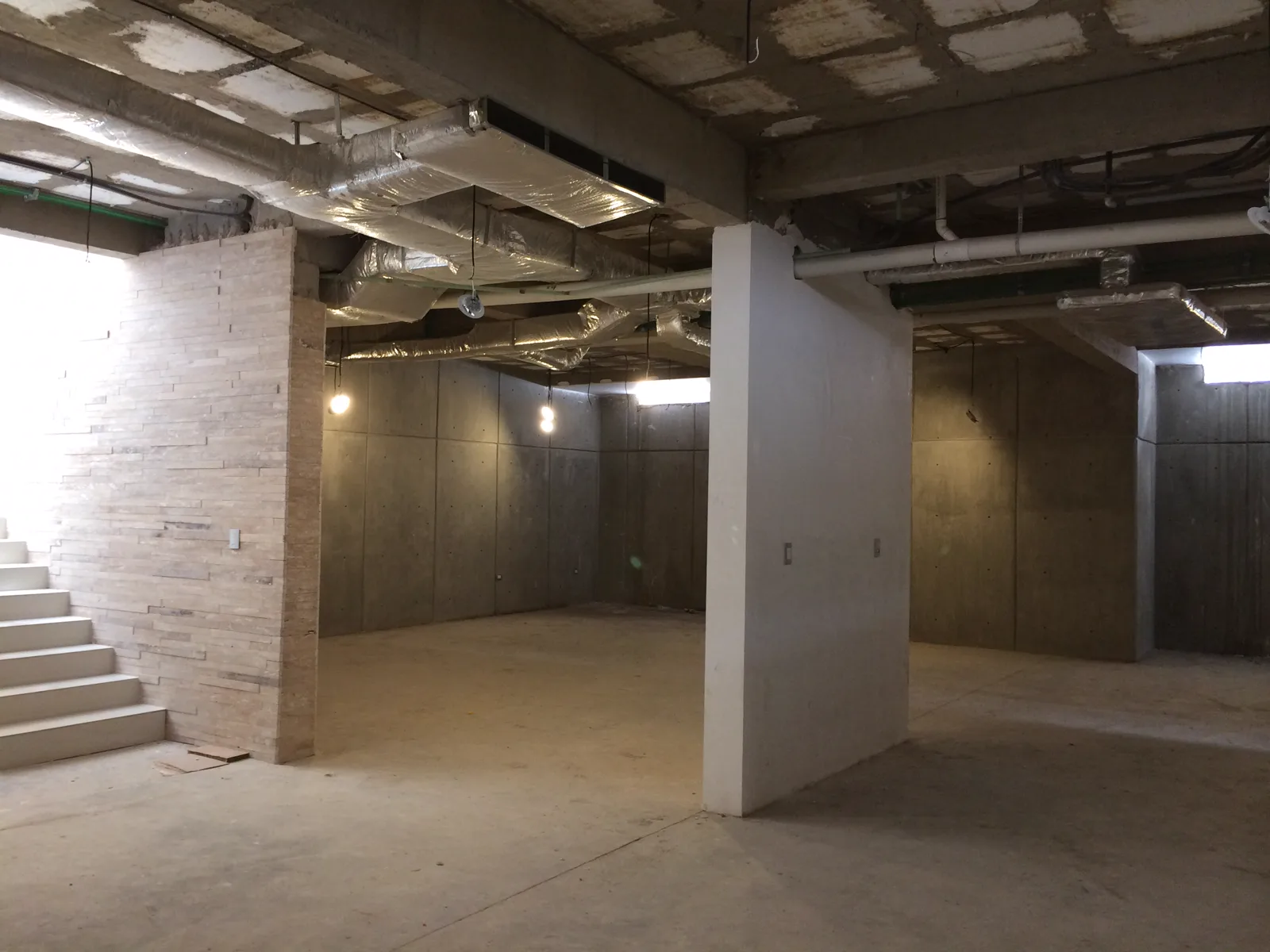Sótano de Construcción Casa Haciendas con muros de concreto colado, instalaciones en el techo y la escalera a la izquierda.